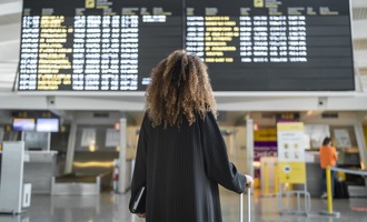 Passenger looking a flight information screen at an airport.jpg