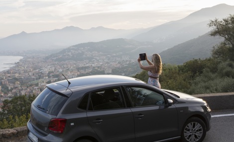 Tourist taking picture in front of a rental car.jpg