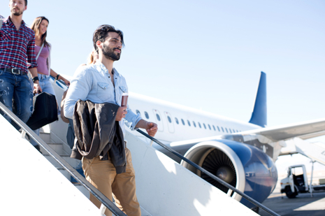 Passengers walking down stairs with aircraft in the background.jpg