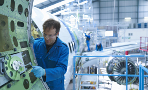 Aircraft engineer fixing a commercial aircraft door inside a hangar