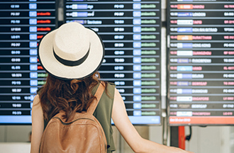 Traveler looking at airport flight schedule screen