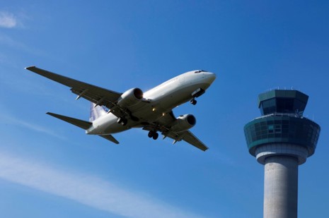 Aircraft in sky passing atm tower